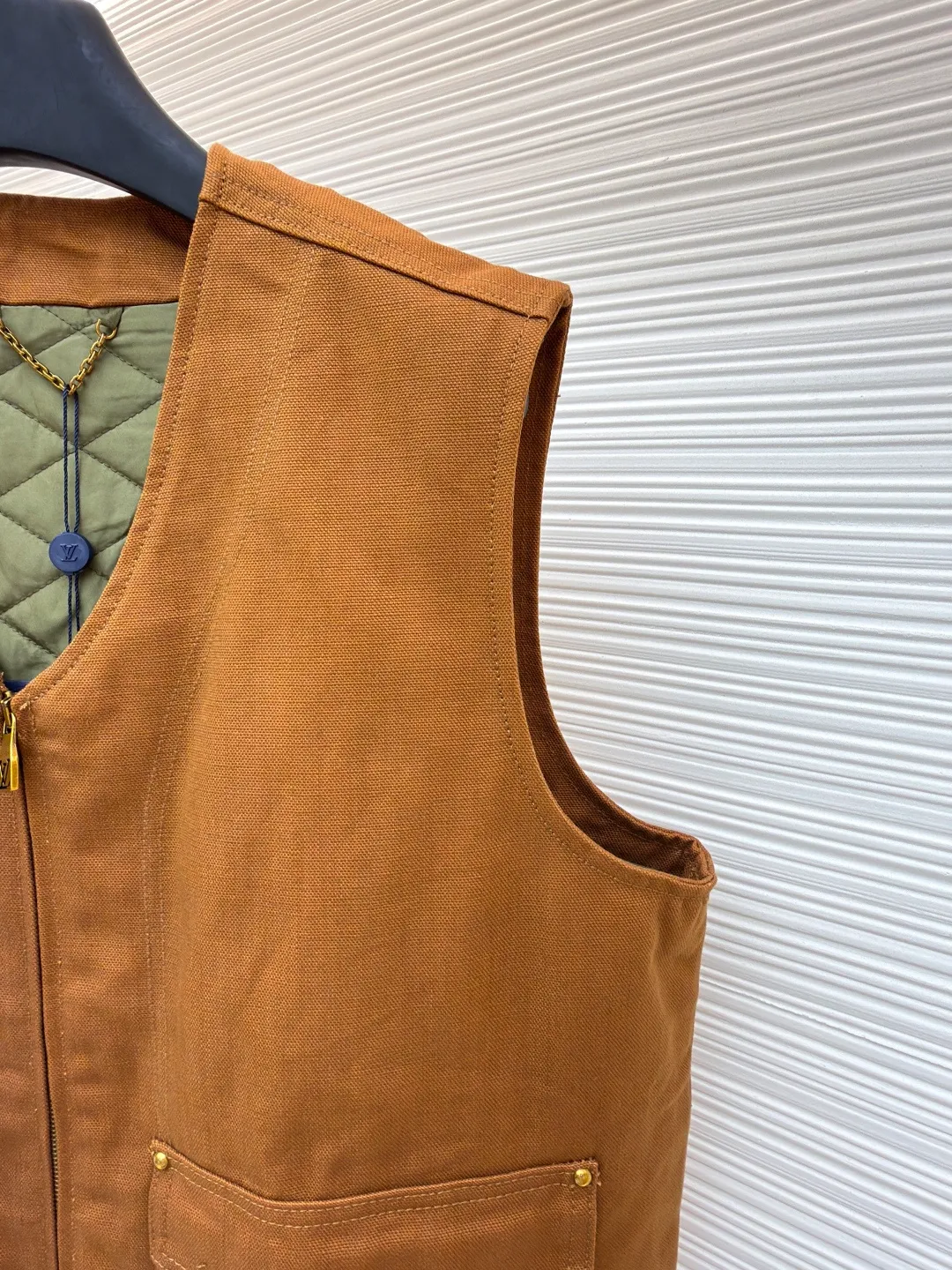 LOUIS VUITTON Nigo joint portrait work vest ●Original version: Purchased and developed for 16999 ●Item number: 1681331-B75 ●Fabric: denim fabric ●Technology: printing production ●Color: brown ●Version: fitted version ●Weight: about 785 grams ●Size: S-M-L-XL ●Description: Made of high-quality brown twill fabric, the texture is crisp and wear-resistant. The stability and texture of the fabric are ensured through fine weaving technology, which provides good support for the vest. The brand logo embroidery on the left uses a combination of bead embroidery and thread embroidery. The beads are arranged regularly, the embroidery stitches are fine, the pattern has a strong three-dimensional effect, and it is perfectly integrated with the fabric, highlighting the brand's luxurious craftsmanship. It adopts three-dimensional tailoring to fit the human body shape, making it comfortable to wear and fashionable. Double-thread reinforcement technology is used during sewing, the seams are smooth and compliant, the stitch spacing is even, and the lines are straight, reflecting the exquisite level of garment making. The buttons on the pockets are custom-made metal buttons with a smooth surface and brand details, high-quality texture and strong durability; the zipper is also customized by the brand, with the zipper puller bearing the brand logo, and the zipper is smooth and easy to pull. The quilted lining on the inside not only increases the warmth of the vest, but also improves the overall sophistication. The quilting lines are regular and reflect the meticulous craftsmanship. The design of the large pockets is both practical and decorative, with neat stitching on the edges of the pockets; the lines of the neckline and body are simple and elegant, and the overall craftsmanship details reflect the brand's high-end production standards. The overall wiring is straight and delicate, the fabric is comfortable and soft, and the color is consistent without color difference. It can be matched with the same style to create a fashionable look and control various occasions. Customized accessories, complete with three standards, same style for men and women!